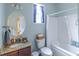 Well-lit bathroom featuring a granite countertop, white tub with shower, and ample natural light at 7217 Mossy Creek Ln, Hanahan, SC 29410