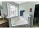 Bright bathroom with a large soaking tub, granite countertop, and a view of the neighborhood at 7217 Mossy Creek Ln, Hanahan, SC 29410