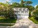 Beautiful two-story home featuring a three-car garage, a welcoming front porch, and lush landscaping at 7217 Mossy Creek Ln, Hanahan, SC 29410