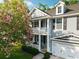 Charming two-story home with a cozy front porch and blooming tree offering shade and curb appeal at 7217 Mossy Creek Ln, Hanahan, SC 29410