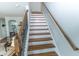 Elegant staircase with wood treads, white risers, and a dark wood railing, leading to the upper level at 7217 Mossy Creek Ln, Hanahan, SC 29410