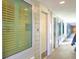 Hallway view with unit doors, and multiple window shuttered views to the outdoors at 1126 Ocean Blvd # 109, Isle of Palms, SC 29451