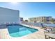 Outdoor pool area with clear blue water, lounge chairs, and buildings in the background at 1126 Ocean Blvd # 109, Isle of Palms, SC 29451