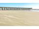 Expansive sandy beach, perfect for walks, and views of the wooden fishing pier at 1126 Ocean Blvd # 203, Isle of Palms, SC 29451