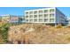Exterior building view showcasing a beachfront walkway, offering direct access to the sandy shores at 1126 Ocean Blvd # 203, Isle of Palms, SC 29451