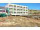 Exterior building view showcasing a beachfront walkway, offering direct access to the sandy shores at 1126 Ocean Blvd # 203, Isle of Palms, SC 29451