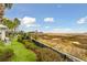 Beautiful backyard view featuring palm trees, grass, chairs, and marsh views at 118 Cooper River Dr, Mount Pleasant, SC 29464