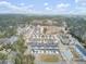 An aerial view displays a community with townhomes and single-Gathering homes, accented by ponds and verdant trees at 129 Sabal Ct, Summerville, SC 29483