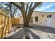 Cozy backyard featuring a large tree, gravel, and a charming, newly-painted exterior at 1508 Greenbay Dr, North Charleston, SC 29406