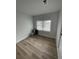Empty bedroom with wood-look flooring, white walls, and a large window at 1508 Greenbay Dr, North Charleston, SC 29406