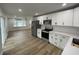 Modern kitchen featuring stainless steel appliances, white cabinets, and sleek countertops, seamlessly flowing into the living area at 1508 Greenbay Dr, North Charleston, SC 29406