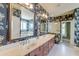 Elegant bathroom with a double vanity, decorative wallpaper, a framed mirror, and a glass-enclosed shower at 1756 Indigo Island Dr, Hanahan, SC 29410