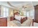 Luxurious main bedroom with tray ceilings, a four-poster bed, hardwood floors, and plantation shutters at 1756 Indigo Island Dr, Hanahan, SC 29410