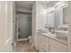 Bright bathroom featuring double sinks, a marble countertop, and a shower with a glass door at 2 Pony Ln, Charleston, SC 29407