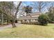 Charming home featuring a manicured lawn, mature trees, and inviting front entrance at 2 Pony Ln, Charleston, SC 29407