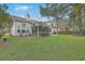 Expansive backyard featuring a screened-in porch, a patio area, lush lawn, and mature trees at 2005 Carriage Way, Summerville, SC 29485