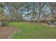 Expansive backyard featuring a lush lawn, mature trees, and a classic wooden fence, great for recreation at 2005 Carriage Way, Summerville, SC 29485