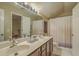 Bright bathroom with a double sink vanity, a large mirror, and a shower with white shower curtain at 2005 Carriage Way, Summerville, SC 29485