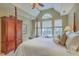 This primary bedroom features vaulted ceilings, a four-poster bed, and large windows to let in plenty of light at 2005 Carriage Way, Summerville, SC 29485