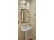 Elegant powder room featuring a pedestal sink, decorative mirror, and stylish fixtures at 2005 Carriage Way, Summerville, SC 29485
