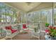 Comfortable screened porch with wicker furniture, providing a relaxing outdoor space for entertaining and leisure at 2005 Carriage Way, Summerville, SC 29485
