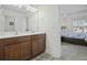 Well-appointed bathroom with double sink vanity, wood cabinets, and doorway to the main bedroom at 213 Crossandra Ave, Summerville, SC 29483