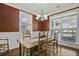 Sun-drenched dining room features a wood table and chairs with three large windows at 213 Crossandra Ave, Summerville, SC 29483