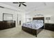 Well-lit main bedroom featuring a tray ceiling, large bed, dresser, and neutral carpeting at 213 Crossandra Ave, Summerville, SC 29483