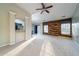 Open-concept living room with a wood accent wall, a ceiling fan, and a sliding glass door to the backyard at 240 Island Green Rd, Goose Creek, SC 29445