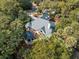 Stunning aerial view of a charming home with lush landscaping, including mature trees and a cozy outdoor fire pit at 2455 The Haul Over, Seabrook Island, SC 29455