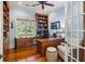 Well-lit home office featuring custom built-ins, a spacious desk, and a view of the landscaped yard at 2455 The Haul Over, Seabrook Island, SC 29455