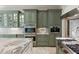 Custom kitchen with marble counters, stainless steel appliances, and green cabinets at 2455 The Haul Over, Seabrook Island, SC 29455