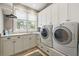 Bright laundry room featuring tile flooring, a window with views, and modern washer and dryer at 2455 The Haul Over, Seabrook Island, SC 29455
