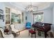 Elegant living room with custom cabinetry, a grand piano, and ample natural light at 2455 The Haul Over, Seabrook Island, SC 29455