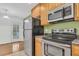 Kitchen with stainless steel appliances, wood cabinets, tile floors, and backyard access through door at 250 Xavier St, Charleston, SC 29414