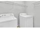 Bright laundry room featuring a white washer, dryer, and wire shelving for organized storage at 250 Xavier St, Charleston, SC 29414