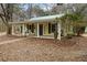 Charming yellow cottage with a covered porch and a metal roof at 2595 Bohicket Rd, Johns Island, SC 29455