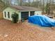 Garage building with ample parking space covered with leaves with car under tarp and trailer at 2595 Bohicket Rd, Johns Island, SC 29455