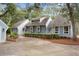 Charming light blue home featuring mature trees, manicured shrubbery, and a long driveway for ample parking at 2653 Seabrook Island Rd, Seabrook Island, SC 29455