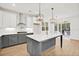 Modern kitchen with a large island, gray cabinets, stainless steel appliances, and hardwood floors at 2924 Lodge Berry Ln, Johns Island, SC 29455