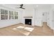 Bright living room with a fireplace, large windows, and hardwood floors at 2924 Lodge Berry Ln, Johns Island, SC 29455