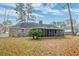 A view of the backyard with a brick home, screened porch, chimney, and lush vegetation at 306 Runnymede Ln, Summerville, SC 29485