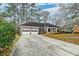 View of the brick home, long driveway, and two-car garage at 306 Runnymede Ln, Summerville, SC 29485