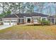 Charming brick home with attached two-car garage and accessible ramp leading to the front door at 306 Runnymede Ln, Summerville, SC 29485