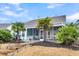 Beautiful backyard features patio with chairs and table, palm trees, and well-manicured lawn at 3115 Cross Vine Ln, Summerville, SC 29483
