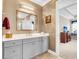 Elegant bathroom with a gray vanity, decorative mirror, and stylish lighting fixtures at 3115 Cross Vine Ln, Summerville, SC 29483