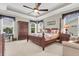 Spacious bedroom with a four-poster bed, ceiling fan, and natural light streaming through the windows at 3115 Cross Vine Ln, Summerville, SC 29483