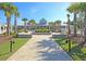A brick walkway leads to the community clubhouse surrounded by lush landscaping, greenery, and palm trees at 3115 Cross Vine Ln, Summerville, SC 29483