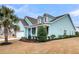 Charming turquoise home features a well-manicured lawn, palm tree, white trim and an attached two-car garage at 3115 Cross Vine Ln, Summerville, SC 29483