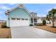 Charming home with blue siding features an attached two-car garage, white trim, and a well-manicured yard at 3115 Cross Vine Ln, Summerville, SC 29483